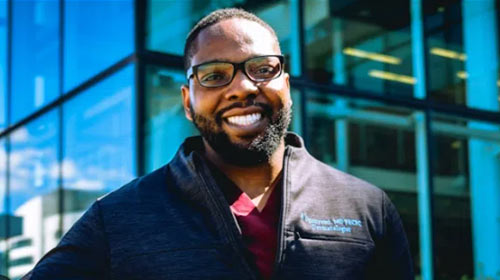 A man with a beard smiling.